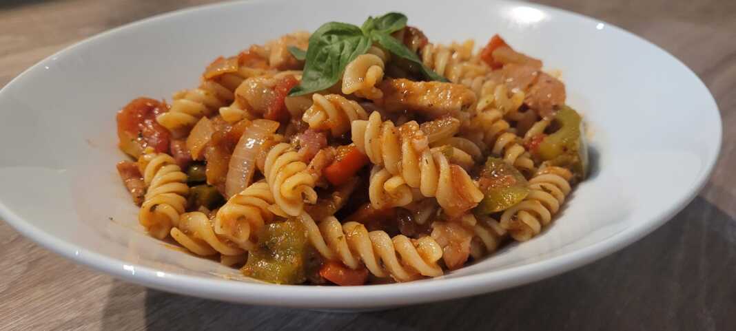 Ζυμαρικά με κοτόπουλο και μπέικον πικάντικο σκόρδο κρεμμύδια, πιπεριές και παρμεζανα  Υλικά συνταγής 400 γρ. ζυμαρικα βίδες 5 φέτες μπέικον 1 στήθος φιλέτο κοτόπουλου, 450-500 γρ. περίπου, κομμένο σε λεπτά κομμάτια αλάτι πιπέρι 2 ½ κ.γ. ανάμικτα αποξηραμένα μυρωδικά, ρίγανη, θυμάρι, βασιλικό, δεντρολίβανο, φασκόμηλο, ματζουράνα (ή ότι εχετε απ αυτά) 1 ½ κ.γ. καπνιστή πάπρικα ½ κ.γ. νιφάδες καυτερής πιπεριάς 4-5 μικρές ώριμες ντομάτες κομμένες σε μικρούς κύβους 1 πρασινη και 1 κόκκινη πιπερια 1 κρεμμυδι ψιλοκομμένο 150 γρ παρμεζάνα 4 σκελίδες σκόρδο, πολτοποημένες Εκτέλεση συνταγής Βάζετε τις βιδες να βράσουν σε μπόλικο αλατισμένο, κοχλαστό νερό, αλ τέντε σύμφωνα με τις οδηγίες της συσκευασίας. Εν τω μεταξύ φτιάχνετε το κοτόπουλο. Σε μια ρηχή, φαρδιά κατσαρόλα, σε μέτρια φωτιά, σοτάρετε τις φέτες μπέικον, χωρίς λιπαντική ουσία, μέχρι να γίνουν τραγανές. Τις βγάζετε από τη κατσαρόλα, τις μεταφέρετε σε πιάτο στρωμένο με χαρτί κουζίνας. Μόλις κρυώσουν τις κόβετε σε λεπτές φέτες. Στραγγίζετε το λίπος που έμεινε από το μπέικον στη κατσαρόλα και ξαναρίχνετε στο ίδιο τηγάνι 2-3 κ.σ. από το λίπος (ή αντί για λίπος ρίχνετε ελαιόλαδο στην ίδια κατσαρόλα). Μόλις ζεσταθεί βάζετε τα κομμάτια κοτόπουλου. Τα αλατοπιπερώνετε τα πασπαλίζετε με λίγα από τα αποξηραμένα μπαχαρικά, τη πάπρικα και τις νιφάδες τσίλι και τα τηγανίζετε, σε παρτίδες, μέχρι να ροδίσουν και ψηθούν και από τις 2 πλευρές, ώστε να μην έχουν ροζ χρώμα στο κέντρο τους. Μη τα παραψήσετε και χάσουν του χυμούς τους. Τα μεταφέρετε σε μπολ και το αφήνετε στην άκρη. Στην ίδια κατσαρόλα προσθέτετε το κρεμμύδι,πιπεριες, τις ψιλοκομμένες ντομάτες και τα υπόλοιπα αποξηραμένα μυρωδικά και ανακατεύετε διαρκώς μέχρι να μαλακώσουν καλά. Προσθέτετε μετα το σκόρδο και σοτάρετε για 1/2 λ επιπλέον. Ρίχνετε 200-300 γρ νερό απο τα ζυμαρικα χαμηλώνετε τη φωτιά από μέτρια σε χαμηλή και αφήνετε να σιγοβράσουν μέχρι να αρχίσει να πήξει η σάλτσα (μπορει να ρίξετε και λιγο κορν φλαουερ να την πηξετε πιο γρηγορα). Στη συνέχεια προσθέτετε τη τριμμένη παρμεζάνα και ανακατεύετε απαλά μέχρι να λιώσει το τυρί. Ρίχνετε, μέσα στη σάλτσα, τα σουρωμένες πέννες, το σοταρισμένο κοτόπουλο και το μπέικον και συνεχίζετε το ανακάτεμα μέχρι να καλυφθούν καλά από τη σάλτσα. Αποσύρετε το φαγητό σας από τη φωτιά το αφήνετε στην άκρη για 5 λ να απορροφηθεί η σάλτσα από τα ζυμαρικά και το κοτόπουλο και στη συνέχεια το σερβίρετε πασπαλίζοντάς το, προαιρετικά, με νιφάδες τσίλι ή τριμμένη παρμεζάνα. Καλή Απόλαυση