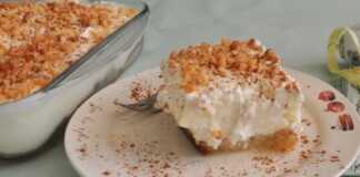 Ένα κομμάτι εκμέκ τσουρέκι σε ένα λευκό πιάτο, που δείχνει μια στρώση σιροπιασμένου τσουρεκιού, μια στρώση κίτρινης κρέμας ζαχαροπλαστικής και μια στρώση λευκής σαντιγί, πασπαλισμένο με αμύγδαλα φιλέ και λίγη κανέλα.