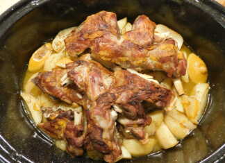 Κατσικάκι λεμονάτο με πατάτες, ψημένο στη γάστρα, με χρυσοκόκκινη πέτσα και πλούσια σάλτσα στον πάτο.