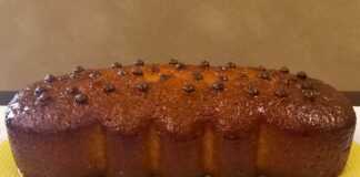 Αφράτο σιροπιαστό κέικ πορτοκάλι, κομμένο σε φέτες, με γλάσο ζάχαρης και φλούδες πορτοκαλιού.