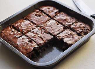 Τετράγωνα κομμάτια ζουμερού, σοκολατένιου μπράουνι με μπανάνα, τοποθετημένα σε μια πιατέλα, με τη χαρακτηριστική τους σκούρα όψη.