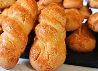 Δίσκος με χρυσαφένια πασχαλινά κουλούρια βανίλιας σε σχήμα πλεξούδας, γυαλιστερά από το αυγό