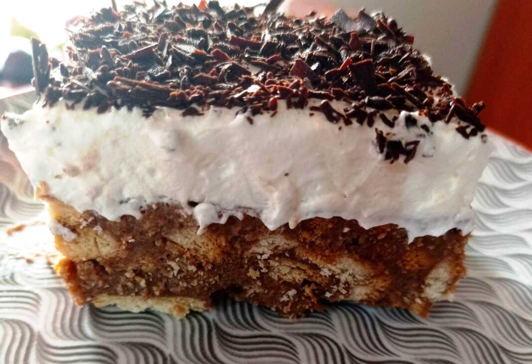 ούρτα ταψιού με μπισκότα, κομμένη σε κομμάτι, με την κρεμώδη υφή και τις στρώσεις της να φαίνονται καθαρά