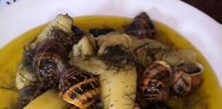 Ζεστοί χοχλιοί με πατάτες και μάραθο σε βαθύ πιάτο, γαρνιρισμένοι με φρέσκα μυρωδικά