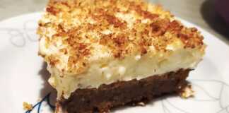 Μια γενναιόδωρη φέτα καρυδόπιτα με πλούσια στρώση κρέμας στο πάνω μέρος, πασπαλισμένη με τριμμένο καρύδι.