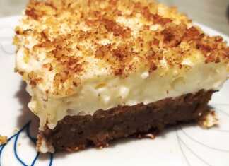 Μια γενναιόδωρη φέτα καρυδόπιτα με πλούσια στρώση κρέμας στο πάνω μέρος, πασπαλισμένη με τριμμένο καρύδι.