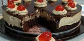 Μια πλούσια πάστα ταψιού με στρώσεις σοκολατένιου παντεσπανιού, κρεμώδους καραμέλας και γυαλιστερού γλάσου σοκολάτας, έτοιμη για σερβίρισμα.