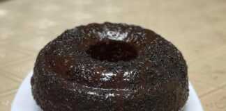 Ένα κομμάτι κέικ "γεωγραφίας" με σχέδια καφέ και ανοιχτόχρωμης ζύμης, καλυμμένο με γλάσο σοκολάτας και λίγη νουτέλα στην επιφάνεια.