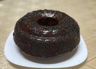 Ένα κομμάτι κέικ "γεωγραφίας" με σχέδια καφέ και ανοιχτόχρωμης ζύμης, καλυμμένο με γλάσο σοκολάτας και λίγη νουτέλα στην επιφάνεια.