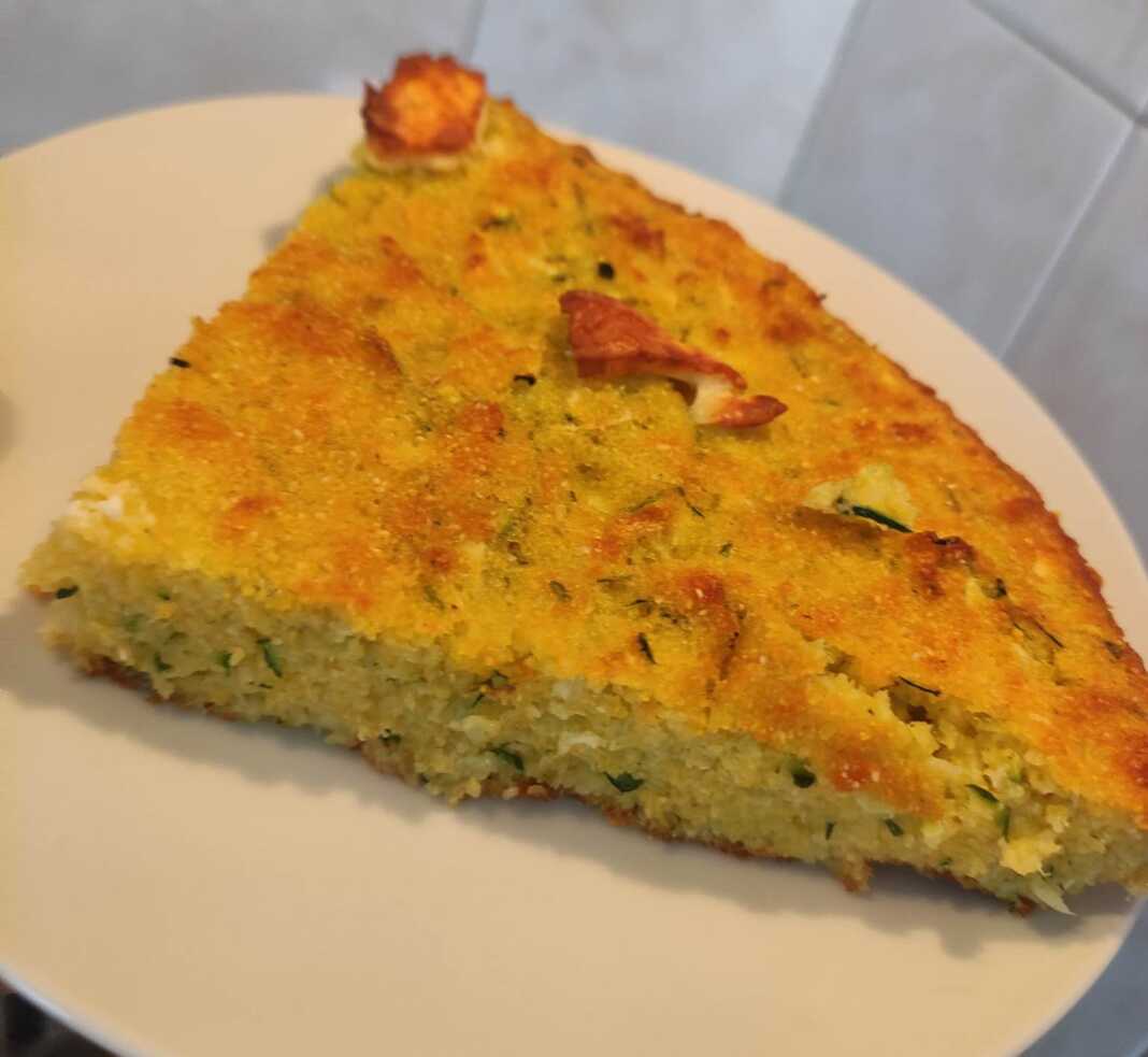 Ένα κομμάτι χρυσαφένιας πίτας με κολοκύθι και φέτα σε ένα πιάτο.