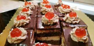 Ένα κομμάτι πλούσιας σοκολατένιας πάστας ταψιού με στρώσεις παντεσπανιού, κρέμας και γλάσου σοκολάτας.