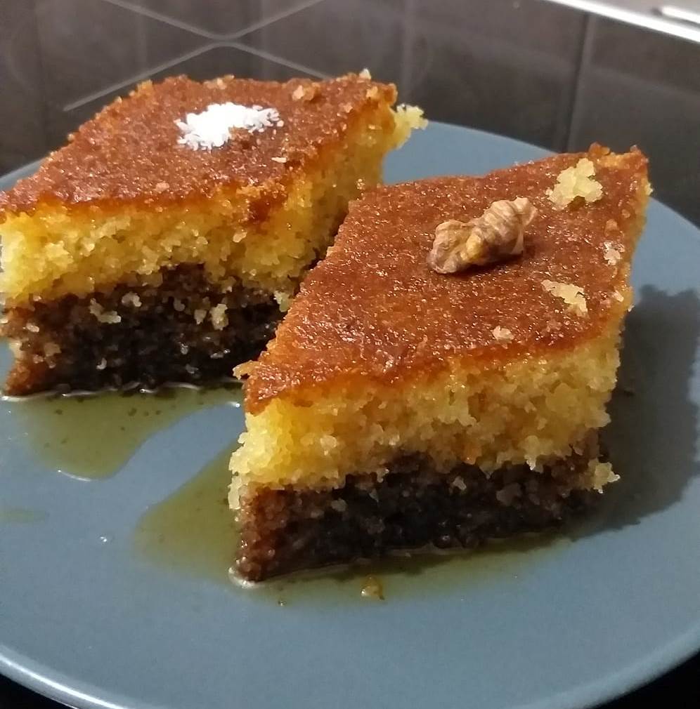 ravaniKaridopita Πιάτο με κομμάτι Ραβανί-Καρυδόπιτα, σιροπιαστό, πασπαλισμένο με κανέλα ή ινδοκάρυδο, έτοιμο για απόλαυση.