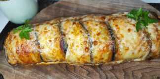 Ένα ολόκληρο ρολό μελιτζάνας με κιμά, με τυρί και ρίγανη από πάνω.