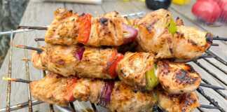 Ξύλινα σουβλάκια με κομμάτια κοτόπουλου, κρεμμυδιού και πιπεριάς, ψημένα στη σχάρα, με ελαφρύ κάψιμο.