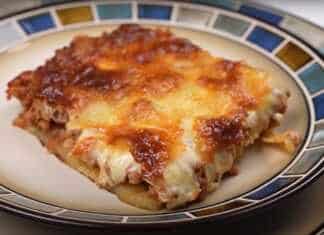 Ταψί με στρώσεις από ροδισμένες πατάτες και κιμά καλυμμένα με λιωμένη μοτσαρέλα που κάνει κρούστα και φρέσκια ρίγανη