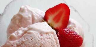 Μπολ με λαχταριστό, κρεμώδες παγωτό φράουλα, γαρνιρισμένο με φρέσκες φράουλες.