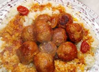 Ένα πιάτο με λευκό ρύζι φούρνου και από πάνω ζεστά κεφτεδάκια περιχυμένα με κόκκινη σάλτσα.