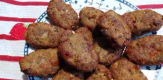 Ένα πιάτο γεμάτο χρυσαφένιους, στρογγυλούς μελιτζανοκεφτέδες με φέτα, έτοιμους για σερβίρισμα.