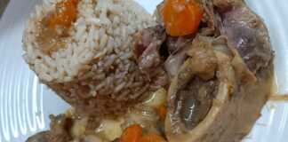 Πιάτο με μοσχαρίσιο οσομπούκο (κομμάτια κρέατος με το κόκαλο) περιχυμένο με λεμονάτη σάλτσα, δίπλα σε βρασμένο καστανό ρύζι.