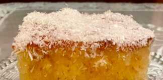 Ένα κομμάτι ραβανί σιροπιασμένο σε ένα πιάτο, πασπαλισμένο με λευκό ινδοκάρυδο.