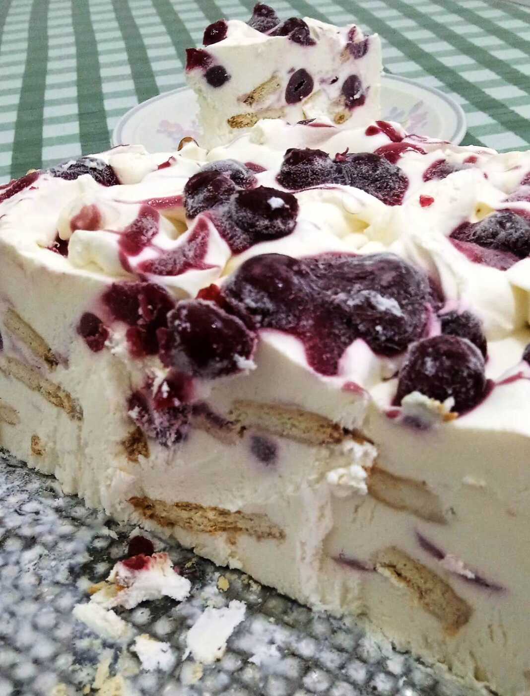 tortaCheese cake Μια λαχταριστή φέτα από τούρτα παγωτό cheesecake με σάλτσα βύσσινο και θρυμματισμένα μπισκότα.
