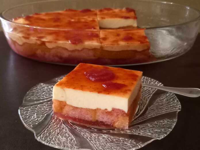 glikoPsigio1 Ένα κομμάτι δροσερό γλυκό ψυγείου με στρώσεις από σπασμένες φρυγανιές, κόκκινο ζελέ, λευκή κρέμα και μαρμελάδα φράουλα στην κορυφή.