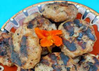 Καλοψημένα μπιφτέκια πάνω σε σχαροτήγανο με έντονες ρίγες ψησίματος, συνοδευόμενα από φρέσκια ρίγανη και ελαιόλαδο