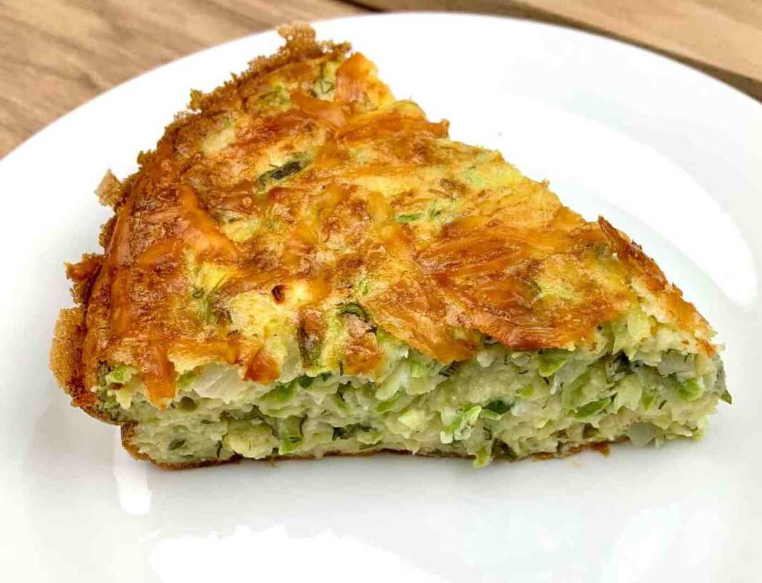 Ομελέτα Φούρνου με Κολοκυθάκια (Σφουγγάτο), κομμένη σε τετράγωνα κομμάτια, με ροδισμένη επιφάνεια.