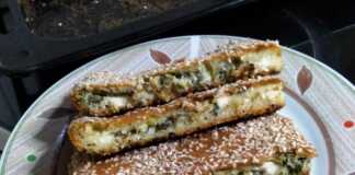 Σπανακόπιτα χωρίς φύλλο, ψημένη, πασπαλισμένη με σουσάμι, κομμένη σε τετράγωνα κομμάτια.