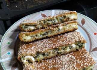 Σπανακόπιτα χωρίς φύλλο, ψημένη, πασπαλισμένη με σουσάμι, κομμένη σε τετράγωνα κομμάτια.