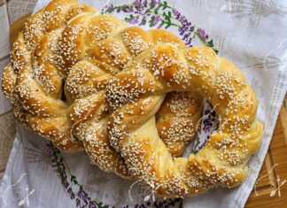 Χρυσαφένια πλεγμένα τυροκούλουρα σε ένα ταψί με λαδόκολλα.