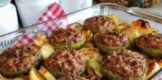 Ψητά γεμιστά κολοκυθάκια με κιμά Ένα πυρέξ με χρυσαφένια, ψητά γεμιστά κολοκυθάκια με κιμά, περιτριγυρισμένα από ψητές πατάτες, κρεμμύδια και σκόρδο.