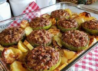 Ένα πυρέξ με χρυσαφένια, ψητά γεμιστά κολοκυθάκια με κιμά, περιτριγυρισμένα από ψητές πατάτες, κρεμμύδια και σκόρδο.