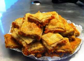 Μια χωριάτικη κολοκυθόπιτα με χειροποίητο φύλλο πασπαλισμένη με ζάχαρη και κανέλα κομμένη σε παραδοσιακές μοίρες