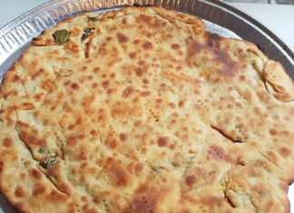 Μια χρυσαφένια, τηγανισμένη Σαΐτια, κομμένη σε κομμάτια, με πρασινάδα (πιθανόν δυόσμο) να φαίνεται από τη γέμιση.