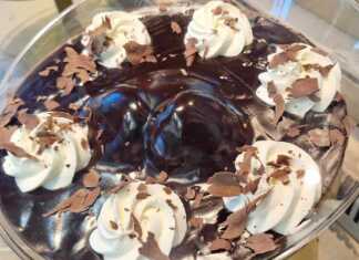 Ένα μπολ γεμάτο σπιτικό προφιτερόλ με στρώσεις από σουδάκια, πλούσια σοκολάτα και σαντιγί, διακοσμημένο με τριμμένη σοκολάτα.