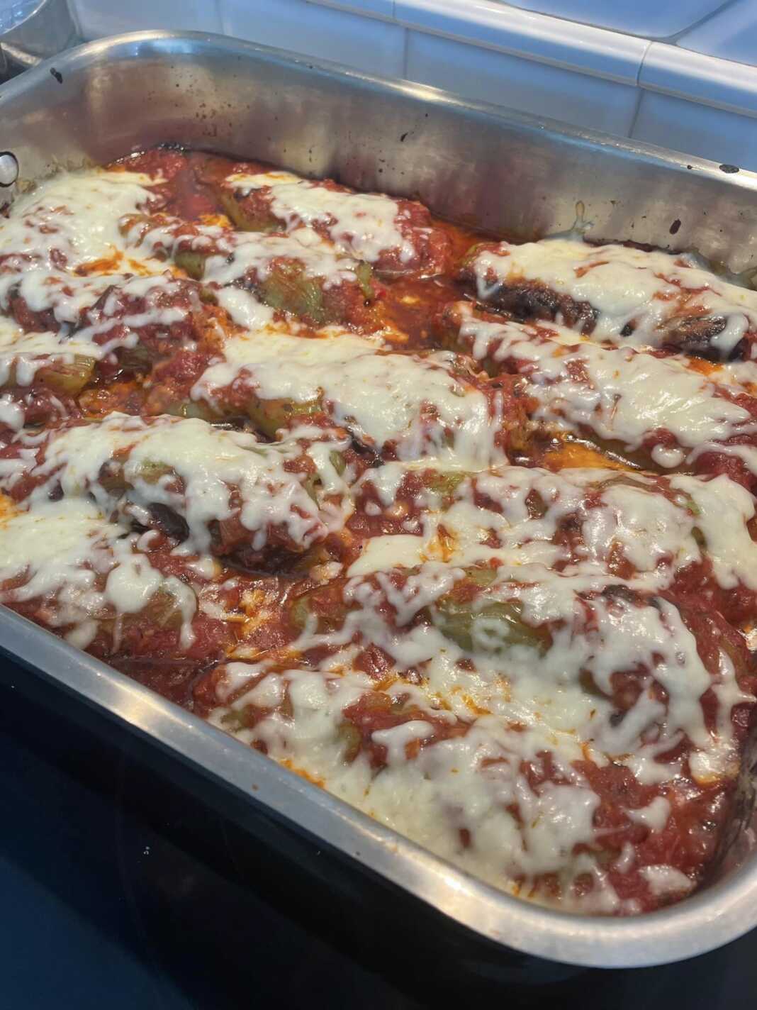 Γεμιστές πιπεριές με κόκκινη σάλτσα και από πάνω μοτσαρέλα.