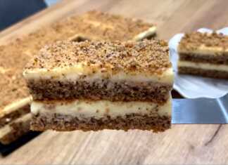 Ένα λαχταριστό κέικ με καρύδι σε στρώσεις με λευκή κρέμα πασπαλισμένο με ψίχουλα από τη βάση του