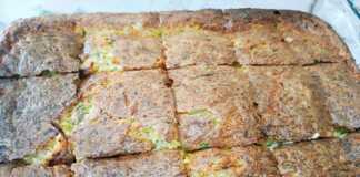 Κοντινό πλάνο στο ταψί με την κολοκυθόπιτα πριν το ψήσιμο, που αναδεικνύει το μείγμα με τα τριμμένα κολοκύθια και τα τυριά