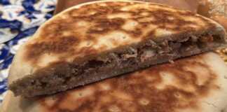 Χρυσαφένιες κρεατόπιτες μαγειρεμένες σε τηγάνι, με γεμάτη γέμιση κρέατος, έτοιμες για σερβίρισμα.