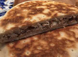 Χρυσαφένιες κρεατόπιτες μαγειρεμένες σε τηγάνι, με γεμάτη γέμιση κρέατος, έτοιμες για σερβίρισμα.