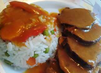 Λεπτές φέτες μοσχαρίσιου νουά περιχυμένες με πυκνή λεμονάτη σάλτσα δίπλα σε πολύχρωμο πιλάφι με αρακά και καρότο