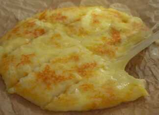 Στρογγυλή πίτσα από πατάτα στο τηγάνι με πλούσια γέμιση λιωμένης μοτσαρέλας που ξεχειλίζει καθώς κόβεται