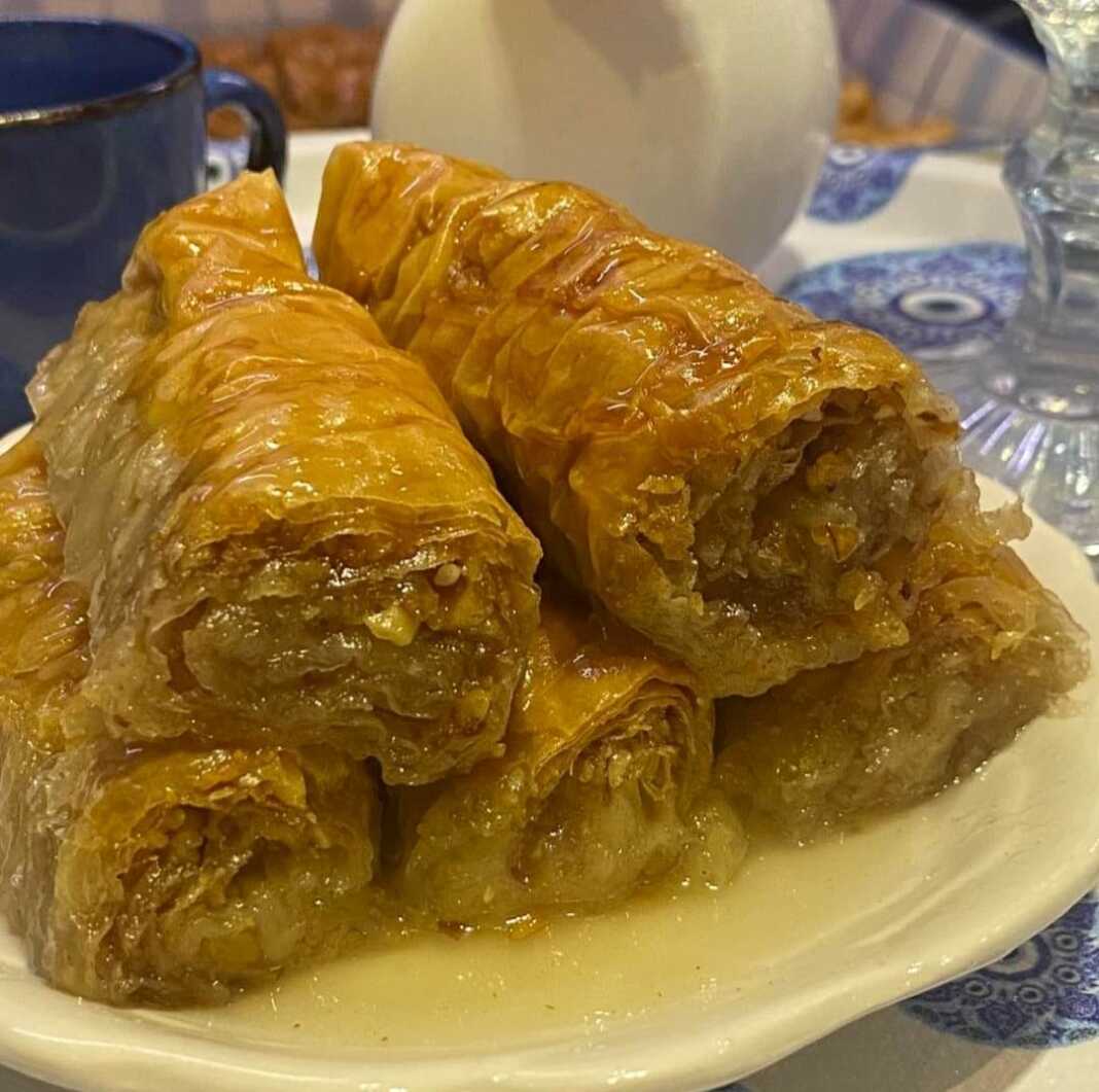 rolakiaMpaklava Φρεσκοψημένο σαραγλί, κομμένο σε μερίδες, με ορατά στρώματα φύλλου και πλούσιο σιρόπι.