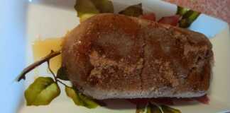 Πιάτο με ζουμερό σιμιγδαλένιο χαλβά, πασπαλισμένο με κανέλα, γαρνιρισμένο με καρύδια και μέλι, σε ρουστίκ φόντο.