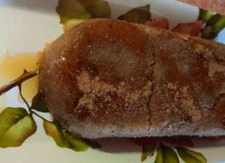 Πιάτο με ζουμερό σιμιγδαλένιο χαλβά, πασπαλισμένο με κανέλα, γαρνιρισμένο με καρύδια και μέλι, σε ρουστίκ φόντο.