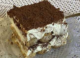 Τιραμισού σε ορθογώνιο σκεύος, με στρώσεις κρέμας και σαβουαγιάρ, πασπαλισμένο με κακάο σκόνη και τριμμένη κουβερτούρα.