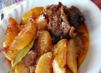 Ένα πιάτο με κοκκινιστή γίδα και πατάτες που ψήνονται στο φούρνο.