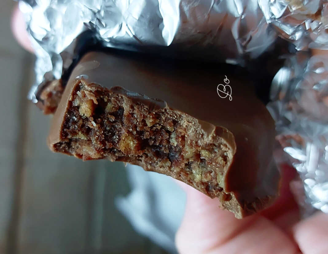 Σπιτικές καριόκες τυλιγμένες σε αλουμινόχαρτο και μερικές κομμένες σε φέτες, δείχνοντας τη γεμάτη φουντούκια και μπισκότο γέμιση