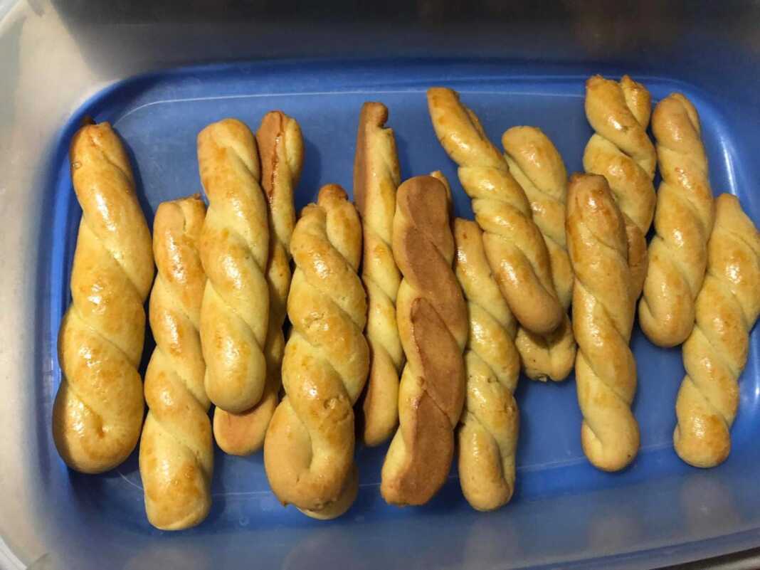 Χρυσαφένια κουλουράκια με άρωμα πορτοκαλιού, σερβιρισμένα σε πιατέλα.